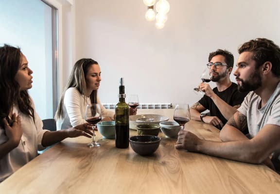 a group of people sitting around a table drinking wine