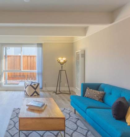 a living room with a blue couch and a coffee table at The Preston at Hillsdale, San Mateo