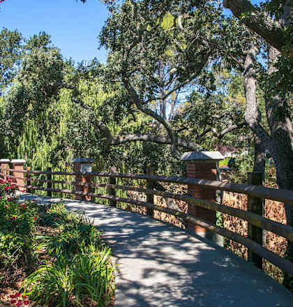 a walkway through a park with trees and a fence  at Danville Park, Danville, CA