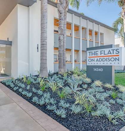 the flats on adelaide building entrance with palm trees at The Flats on Addison, Sherman Oaks California