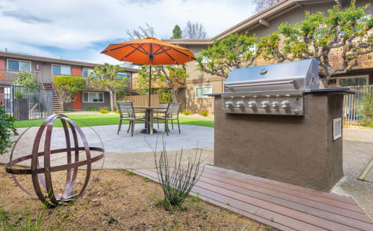 a patio with a grill and a table with an umbrella at Element LLC, Sunnyvale, CA