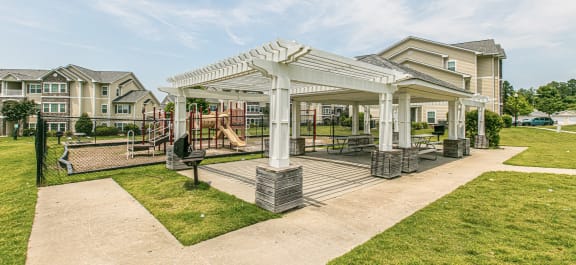 a pergola with a playground in the background at Stone Gate Apartments, Spring Lake, North Carolina