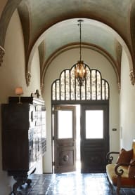 a man walking down a hallway with a chair and a dresser at Villa Carlotta – Furnished Apartments, Los Angeles, 90028