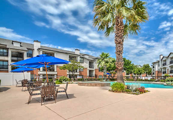 A pool area with chairs and a table.