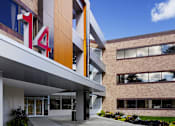 Thumbnail 14 of 21 - A modern building with a glass facade and a number 14 on the side.