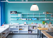Thumbnail 4 of 21 - A blue room with a white table and chairs.