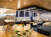 Thumbnail 11 of 21 - A modern office space with a wooden ceiling and furniture.
