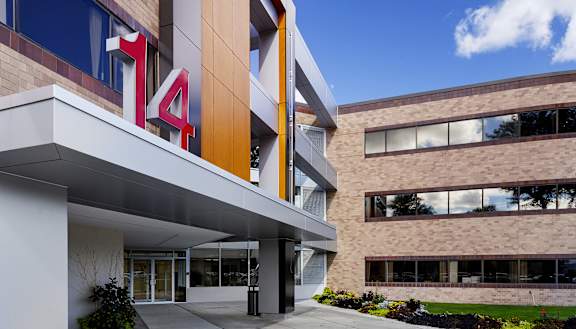 A modern building with a glass facade and a number 14 on the side.
