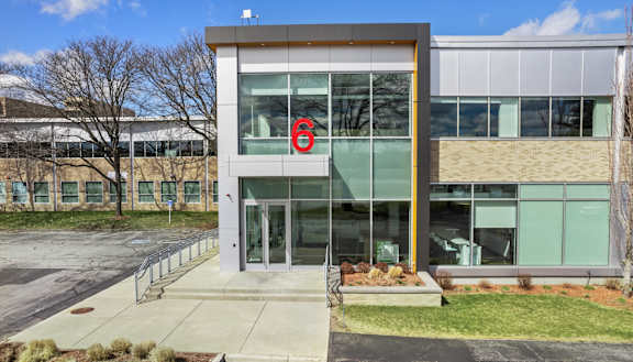 A modern building with a glass facade and a large number 6 on the front.
