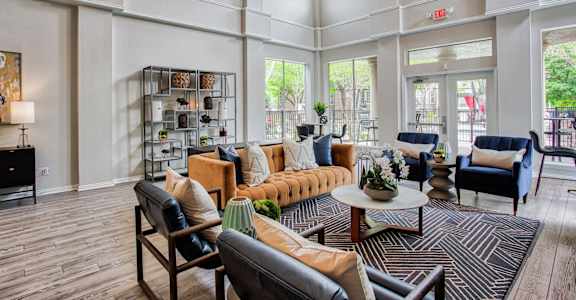 A large room with a couch, chairs, and a table.