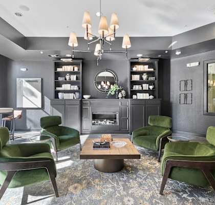A modern living room with green chairs and a fireplace at Prairie Crossing, Farmers Branch, 75244