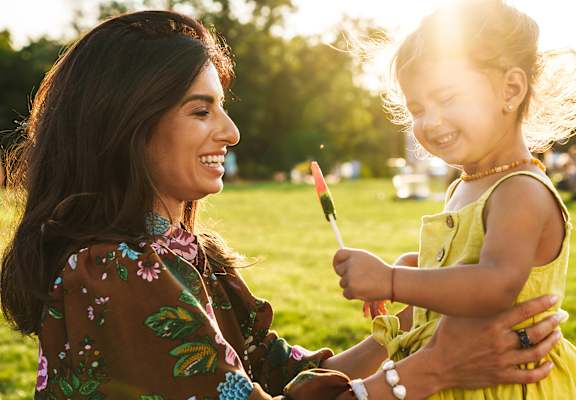 A woman and a child are enjoying a sunny day in a park.