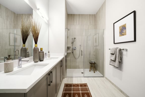 a bathroom with a shower and a sink and a mirror at The Ivy, New Jersey