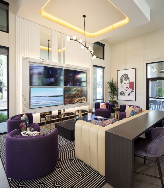 a living room with purple chairs and a long table
