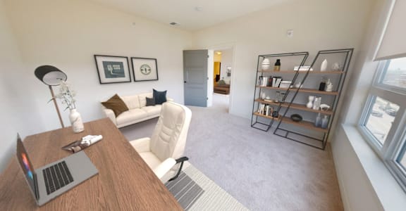 a living room with a couch and a desk with a laptop