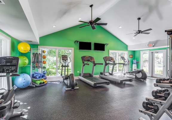 A gym with a green wall and various exercise equipment.