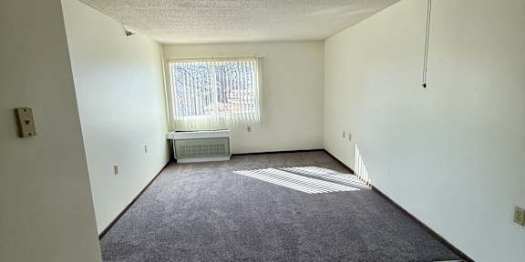 A room with a ceiling fan and a window.