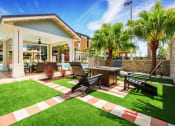 Thumbnail 5 of 12 - Nona Park Village Apartments - outdoor fireplace with seating