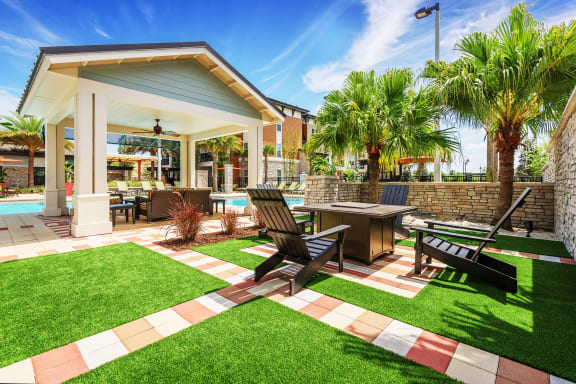 Nona Park Village Apartments - outdoor fireplace with seating