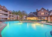 Thumbnail 18 of 18 - Lodge at Cypresswood Apartments - Pool with sundeck at twilight