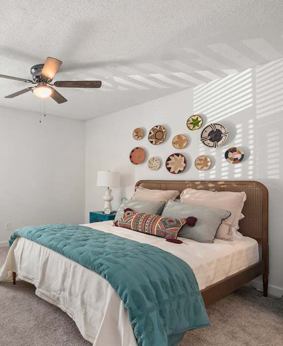 a bedroom with a bed and a ceiling fan