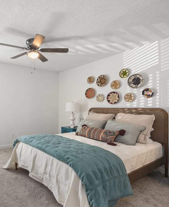 a bedroom with a bed and a ceiling fan
