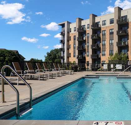 A large swimming pool in front of apartment buildings.