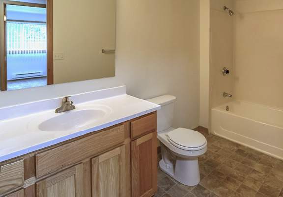 A bathroom with a toilet, sink, and bathtub.