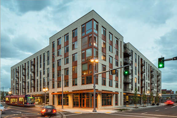 A modern building with a parking lot in front of it.