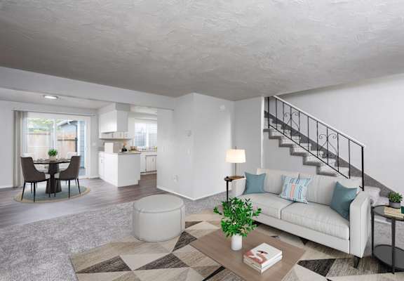 a living room with a couch and a table and a staircase