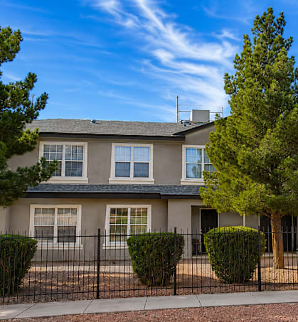A row of houses with trees in front.