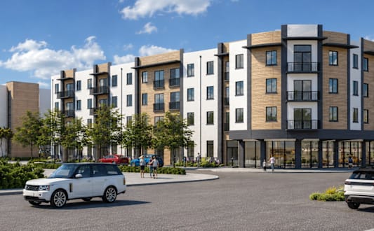 A modern apartment complex with balconies and a pedestrian walkway.