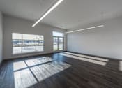 Thumbnail 7 of 7 - A large empty room with wooden floors and windows.