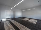 Thumbnail 6 of 7 - A room with wooden floors and white walls.