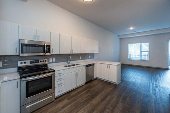 A kitchen with white cabinets and stainless steel appliances.