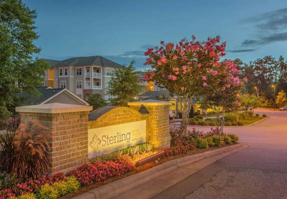 Sterling sign in front of a building with flowers.