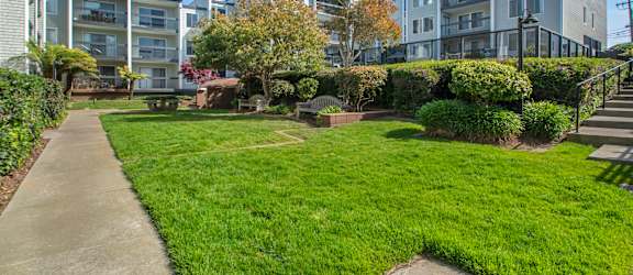 a park with grass and a sidewalk in front of some buildings at Delphine on Diamond, San Francisco, 94131