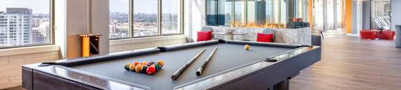 A pool table in a room with a view of the city.
