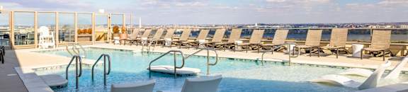 A pool with two chairs and a railing.