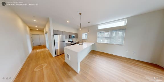 a kitchen with a white island and a stainless steel refrigerator
