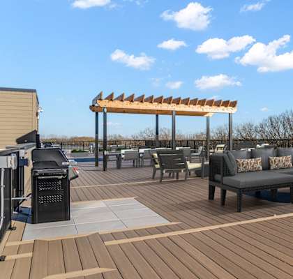 A wooden deck with a table and chairs and a canopy.