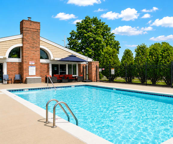 A swimming pool in a backyard with a building in the background.