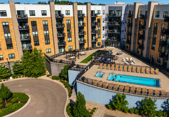 A swimming pool is surrounded by apartment buildings.