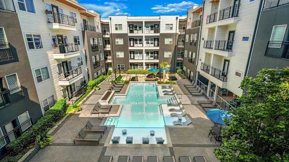 A large swimming pool surrounded by apartment buildings.