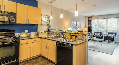 A kitchen with wooden cabinets and black appliances.