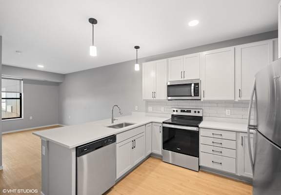 a renovated kitchen with white cabinets and stainless steel appliances