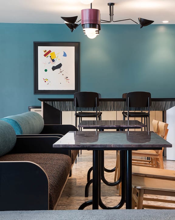a restaurant or other place to eat in a room with tables and chairs at The Flat in Los Angeles, CA