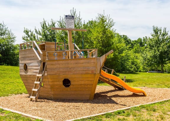 a wooden pirate ship playground in a park