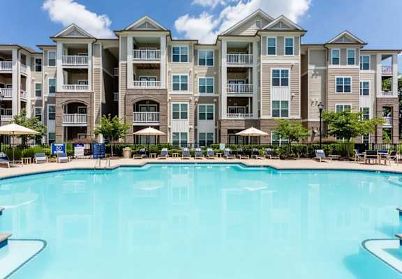 A large swimming pool in front of apartment buildings.