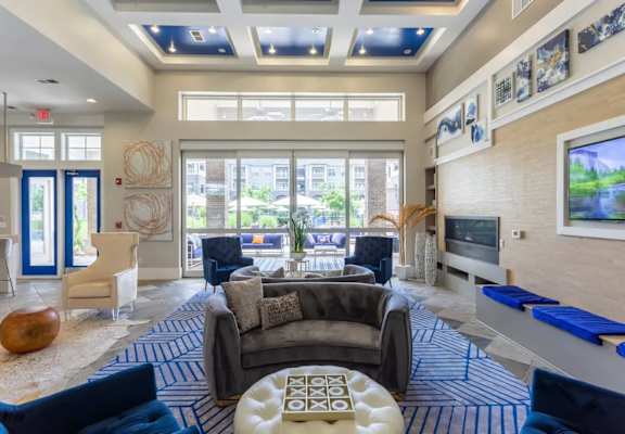 A living room with a blue and white rug and a large window.